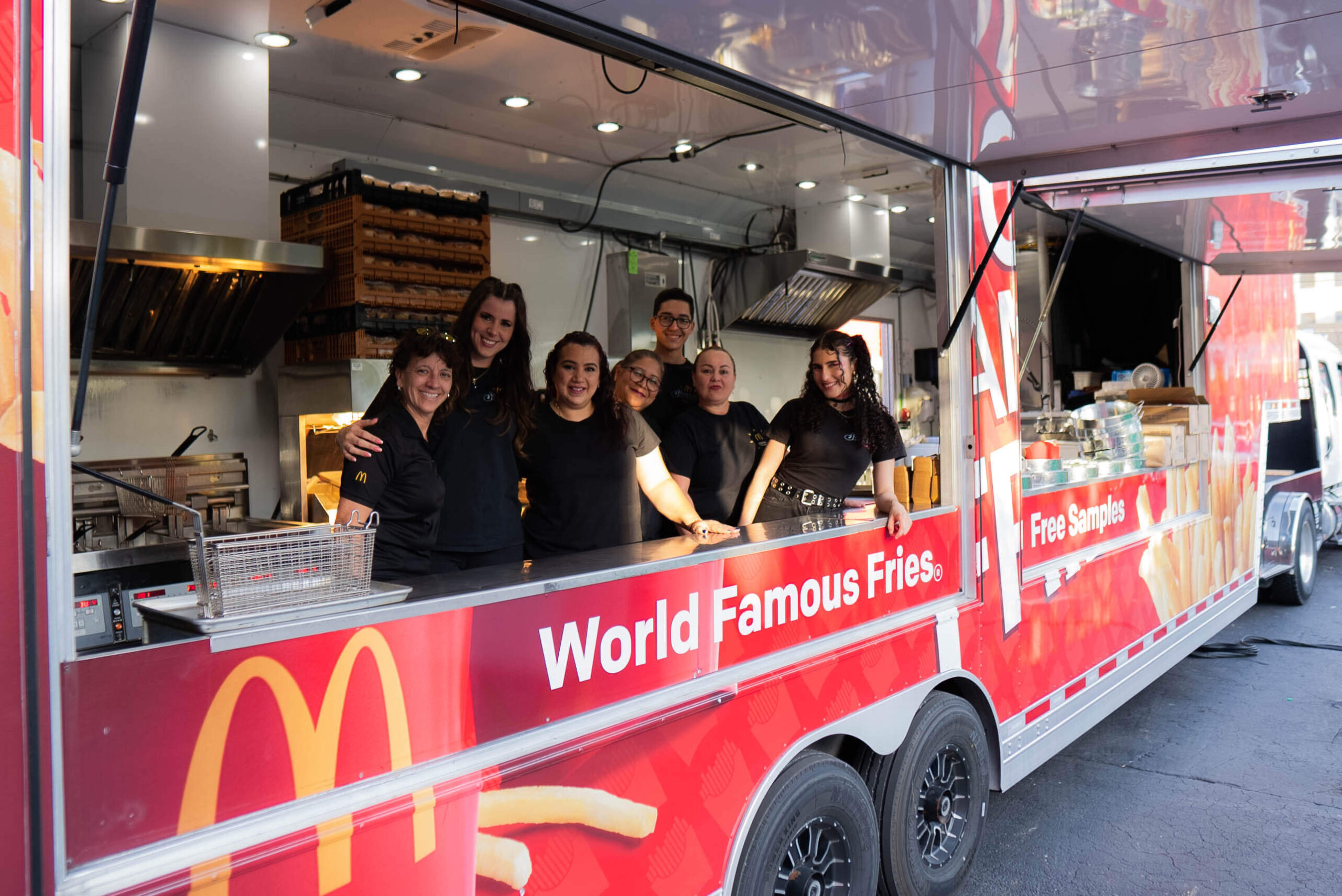 McDonald’s employees serving french fries in the McDonald’s Snack Truck.
